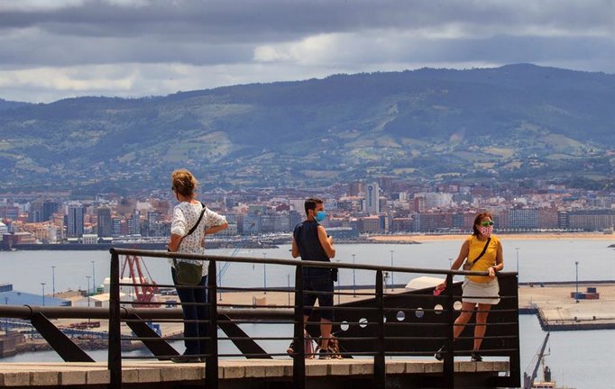 Turistas visitan el castro de Noega, conocido también por castro de la Campa Torres, desde donde se disfrutan las vistas de la ciudad de Gijón, este domingo. EFE/Alberto Morante
