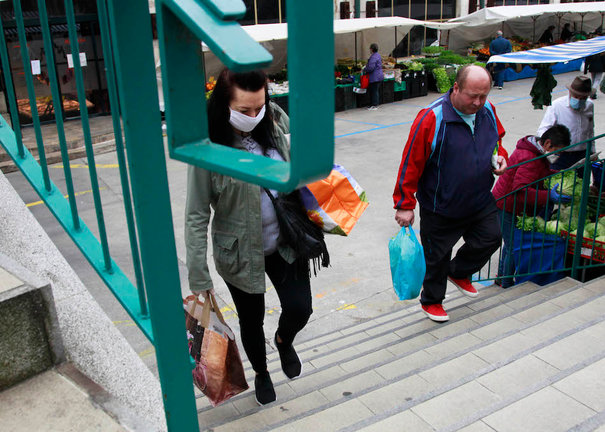 Dos personas salen del Mercado de la Esperanza en Santander. / J.R.