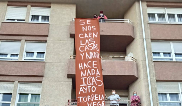 Vecinos junto a una pancarta en donde se puede leer "Se nos caen las casas y nadie hace nada, ICCAS, AYTO. TORRELAVEGA; S.O.S.".