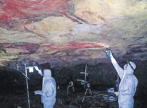 Dos operarios realizan mediciones en la cueva de Altamira. / ALERTA