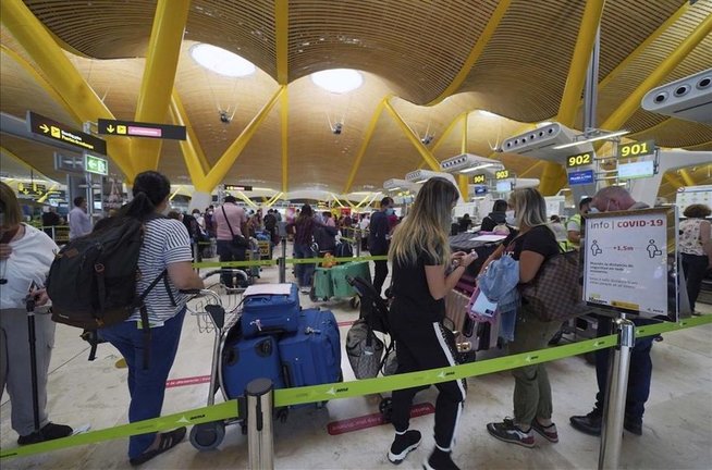 Varias personas esperan para embarcar en el aeropuerto de Barajas. / ALERTA