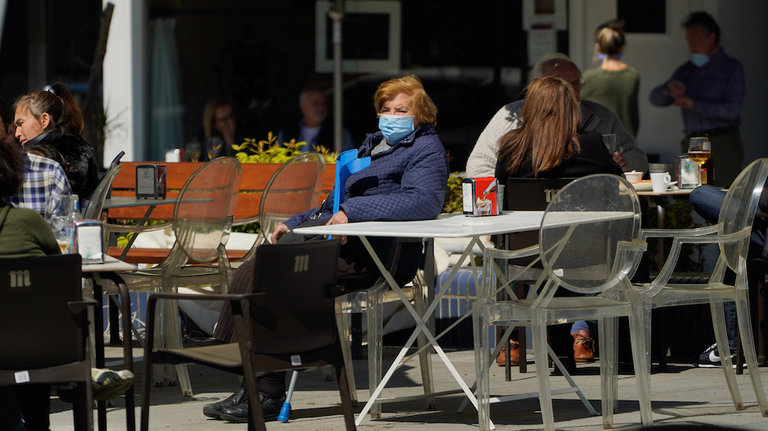 Una persona con mascarilla sentada en una terraza de un establecimiento hostelero en Santander. / Hardy