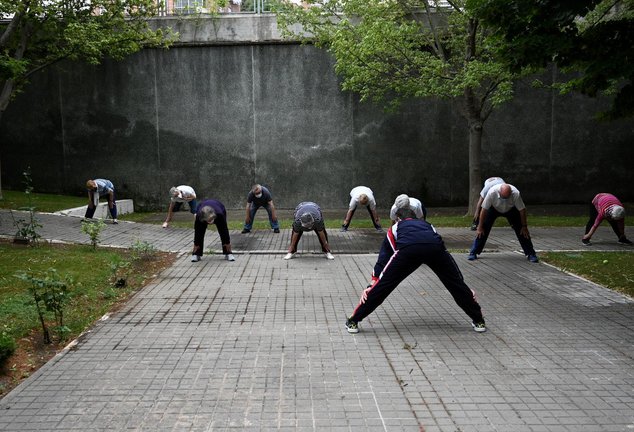 Un grupo de ancianos realiza ejercicio en el jardín de un centro de día de personas mayores de la Comunidad de Madrid