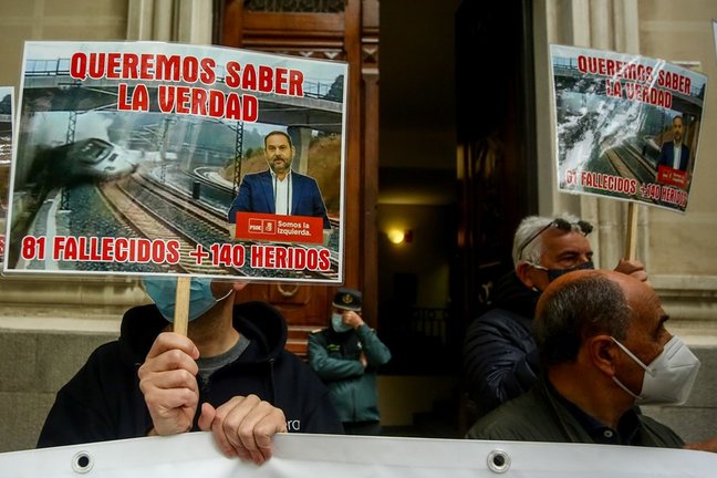Archivo - Varias víctimas del accidente ferroviario del Alvia se concentran con una pancarta y carteles en los que se lee: "Queremos saber la verdad, 81 fallecidos + 140 heridos".