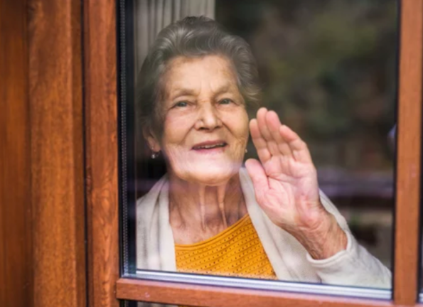 Una anciana mirando por la ventana.
