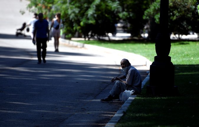 Archivo - Un hombre se sienta a la sombra en el Parque del Retiro.