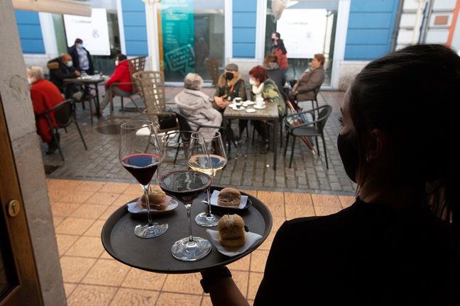 Archivo - Una camarera se dispone a servir en una terraza de un restaurante de Avilés, Asturias (España).