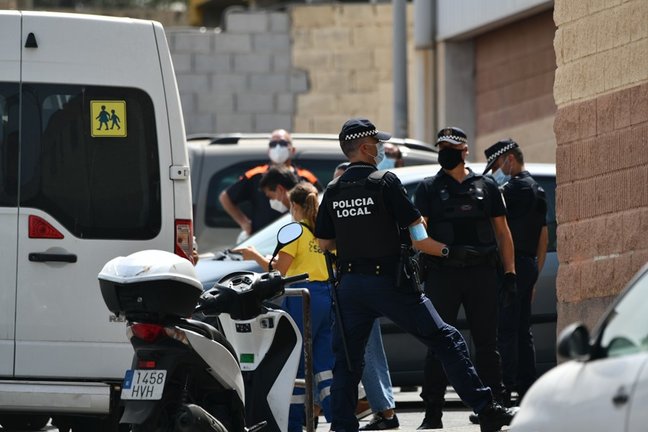 Varios agentes y vehículos de la Policía Local de Ceuta acompañan a menores no acompañados hacia una furgoneta, en las inmediaciones del Polideportivo Santa Amelia, donde fueron acogidos 250 de los 800 menores que llegaron a Ceuta el pasado mes de mayo