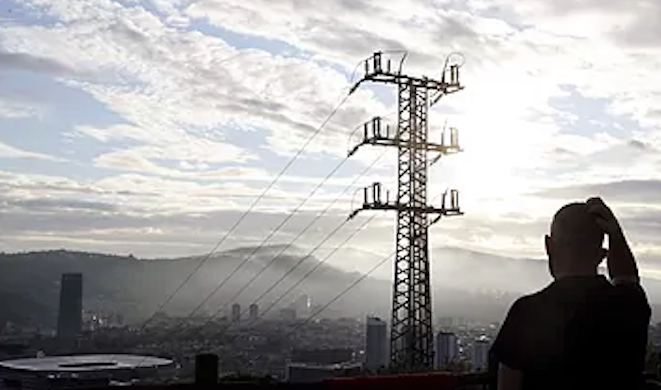 Una persona observa el cableado con el que red eléctrica transporta la energía sobre la ciudad de Bilbao.Luis TejidoEFE