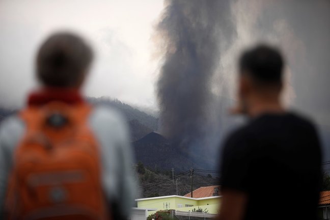 Dos personas observan una boca eruptiva que expulsa lava y piroclastos en la zona de Cabeza de Vaca, a 20 de septiembre de 2021, en El Paso, La Palma, Santa Cruz de Tenerife, Islas Canarias, (España). La erupción volcánica iniciada ayer a las 16 horas en 