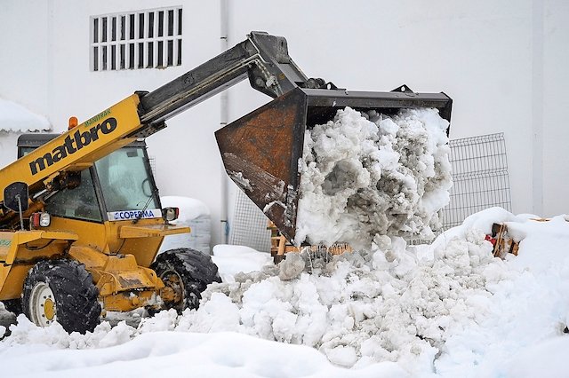 REINOSA, 28/11/2021.- Una máquina excavadora retira la nieve acumulada este domingo en la localidad cántabra de Reinosa. EFE/Pedro Puente Hoyos
