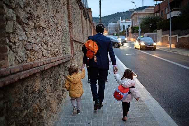 Dos niñas de la mano con su padre a su llegada al primer día de clase. / alerta