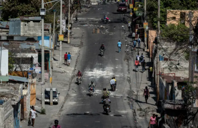 Personas caminan por una calle con bloqueos en el marco de las protestas, el 26 de enero de 2023, en Puerto Príncipe (Haití). EFE/Johnson Sabin