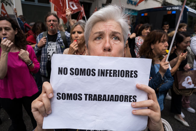 Una mujer sujeta una pancarta durante una protesta de los funcionarios de justicia frente a la sede nacional del PSOE de la calle Génova. / Diego Radamés