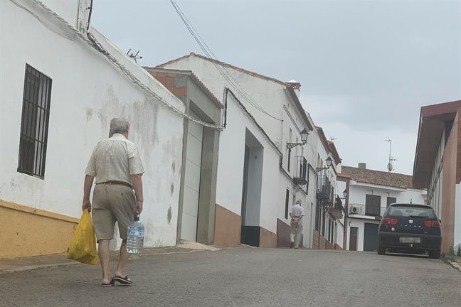 Un vecino de Cumbres Mayores (Huelva) transporta una garrafa de agua para consumir en su casa. EFE / Fermín Cabanillas