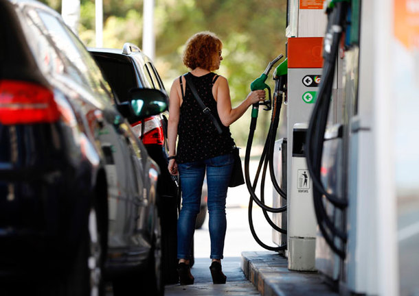 Una mujer echa carburante en una gasolinera.