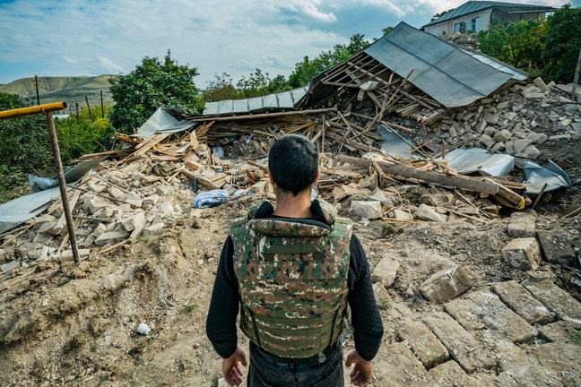 Un militar mira las ruinas de una casa, provocadas por el conflicto entre Armenia y Azerbaiyán. / Celestino ARCE