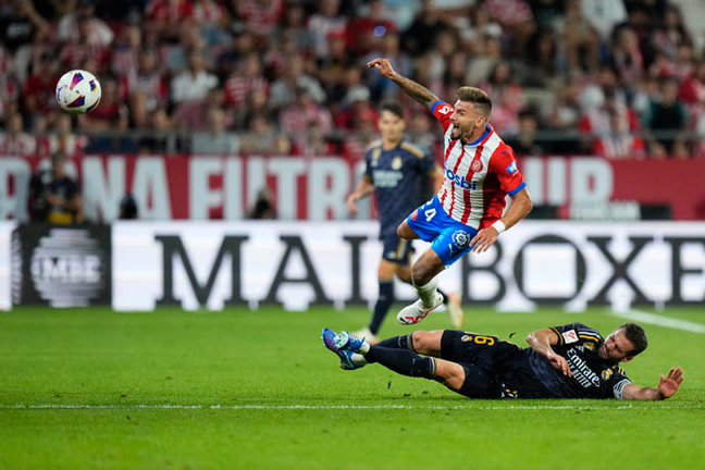 El centrocampista del Girona Cristian Portugués "Portu" (encima) pelea un balón con el defensa del Real Madrid Nacho Fernández. EFE/Siu Wu