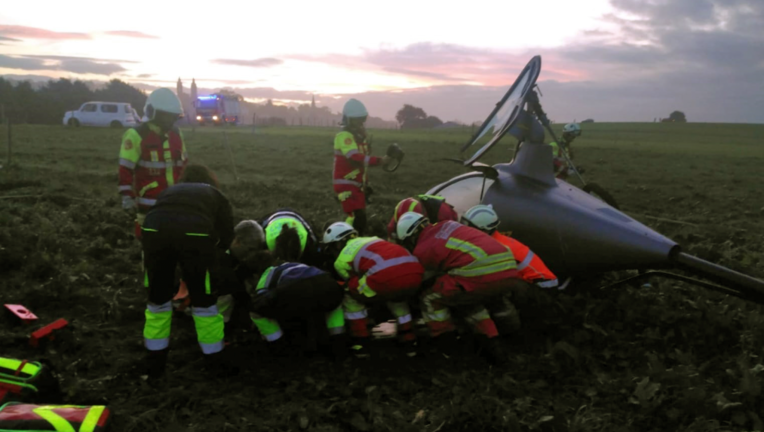 "Los equipos de emergencia trabajan en el lugar del accidente de helicóptero en Cóbreces, luchando por salvar vidas en medio de la tragedia.