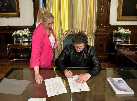 El presidente argentino, Javier Milei, firma un documento en su despacho. EP