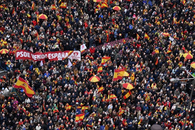 Decenas de personas durante una concentración donde piden la dimisión de Pedro Sánchez, y un cartel con la frase "PSOE vende España". EP / Fernando Sánchez