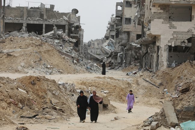 Personas caminando entre los edificios destruidos por los ataques en Gaza. Omar Ashtawy