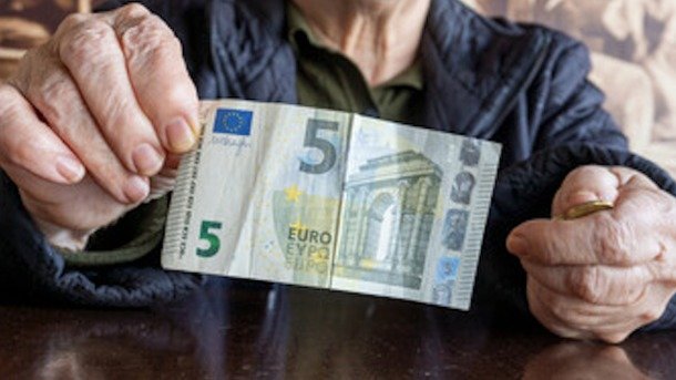 Una pensionista enseña un billete de cinco euros. / ALERTA