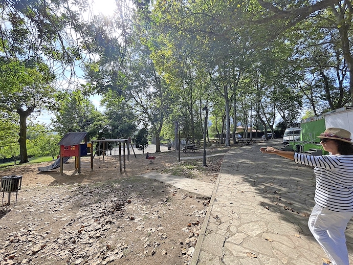 Una de las afectadas, 
señala esta zona de descanso  que desaparecerá junto con los árboles y merenderos para construir una rotonda a un metro del parque infantil. / ALERTA