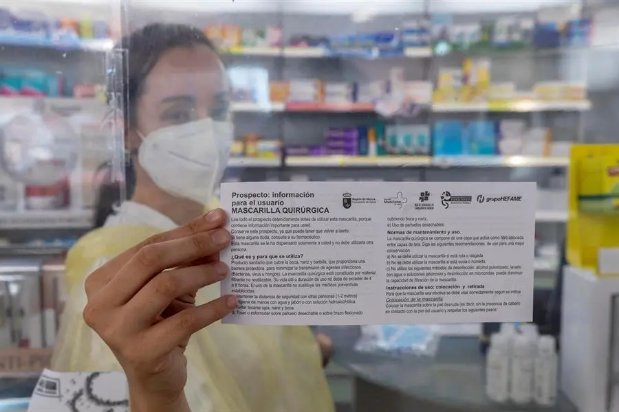 GRAFCVA4483 MURCIA, 
Una empleada de farmacia muestra el prospecto que informa de como usarlas mascarillas quir&uacute;rgicas que entregan a los pensionistas que retiran sus dos mascarillas gratuitas. Desde este lunes los mayores de 65 a&ntilde;os y pacientes vulnerables, unas 225.000 personas en toda la Comunidad de Murcia, podr&aacute;n recoger dos mascarillas gratuita en las casi 600 farmacias de la Regi&oacute;n de Murcia.EFE/Marcial Guill&eacute;n