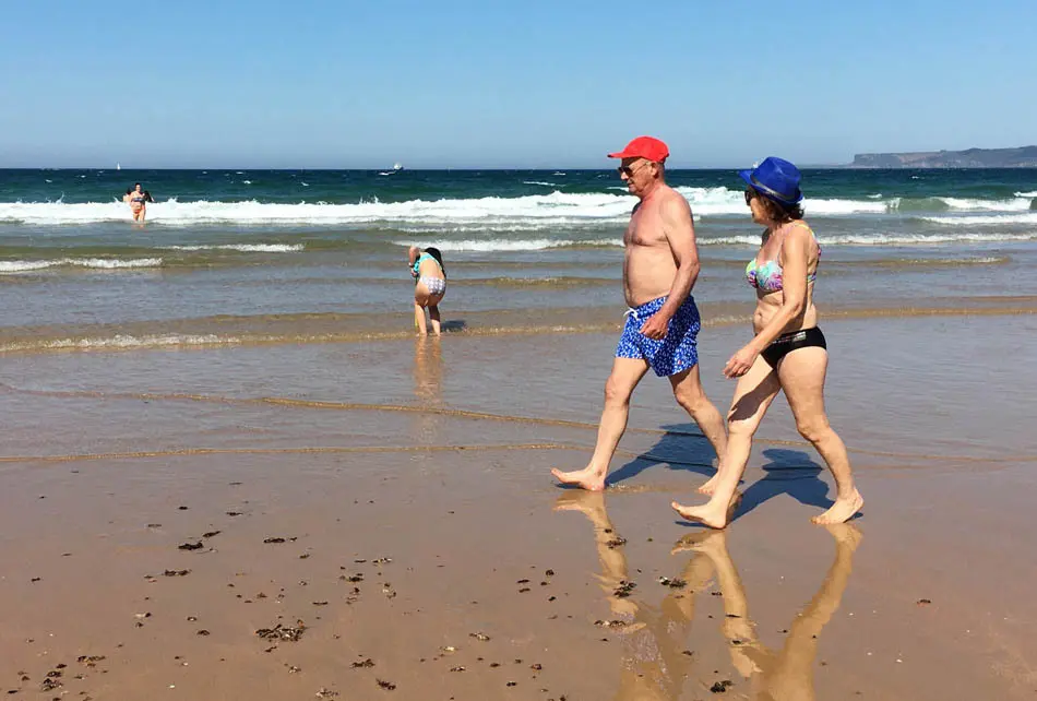 Dos personas pasean junto a la orilla en la playa del Sardinero en Santander, Cantabria. / J. Ram&oacute;n