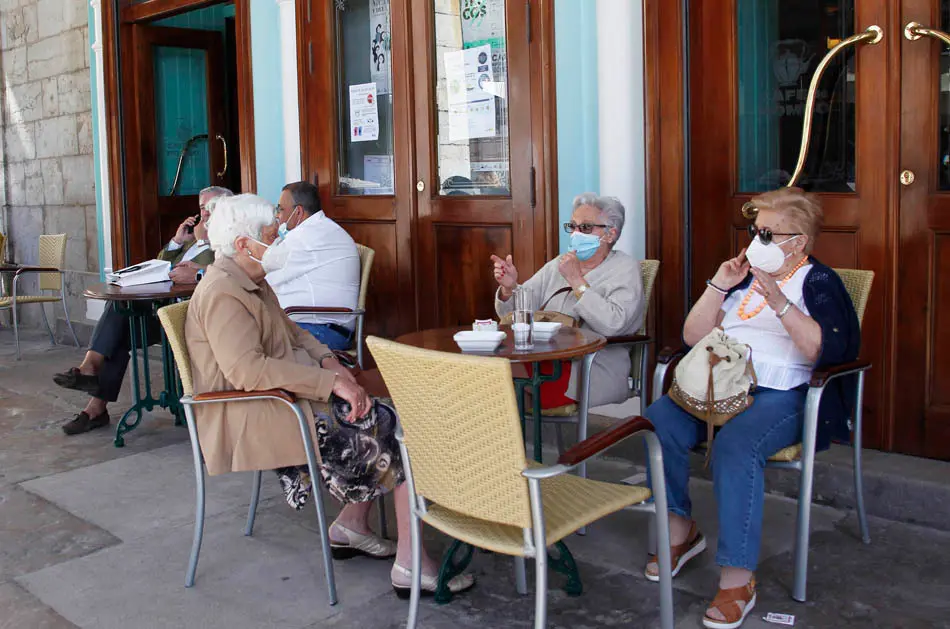 Varias personas disfrutan de la terraza en la plaza Pombo de Santander. / J. Ram&oacute;n