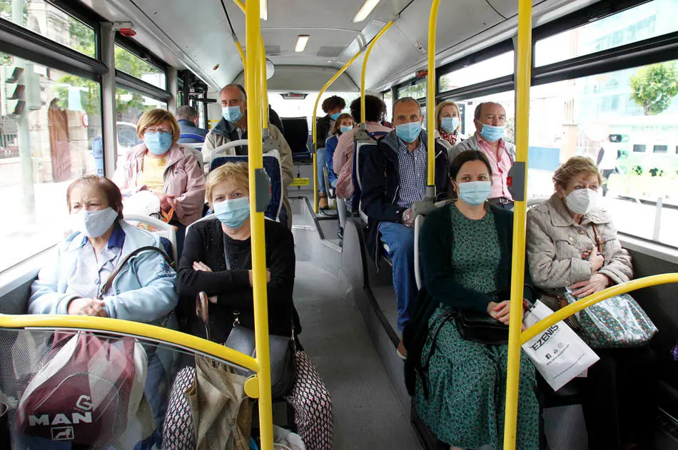 Varias personas con mascarilla sentadas en los asientos de un autob&uacute;s en Santander. / J. RAM&Oacute;N