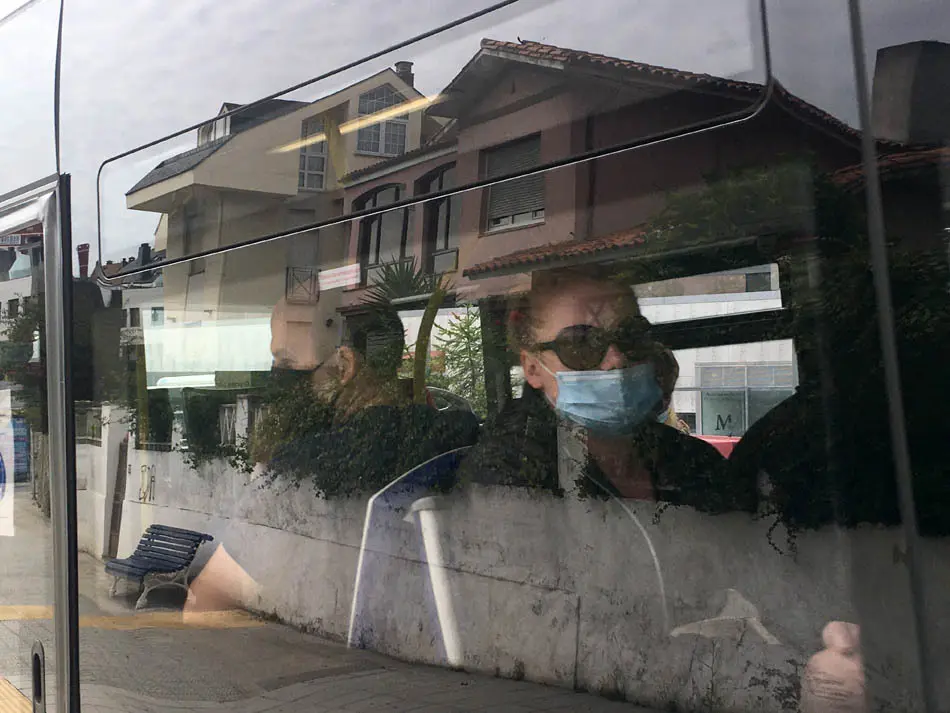 Dos personas sentadas en el autob&uacute;s de Santander con su respectiva mascarilla. / S.D.