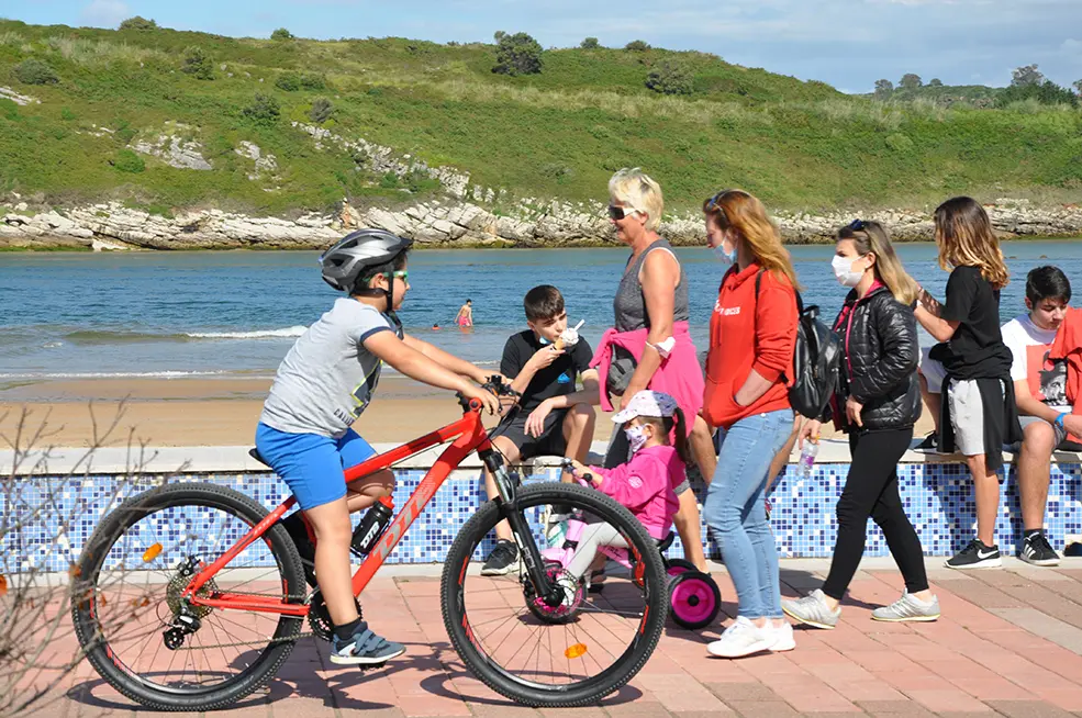 Varias personas disfrutan del d&iacute;a soleado en el pueblo costero de Suances, Cantabria. / S.D.