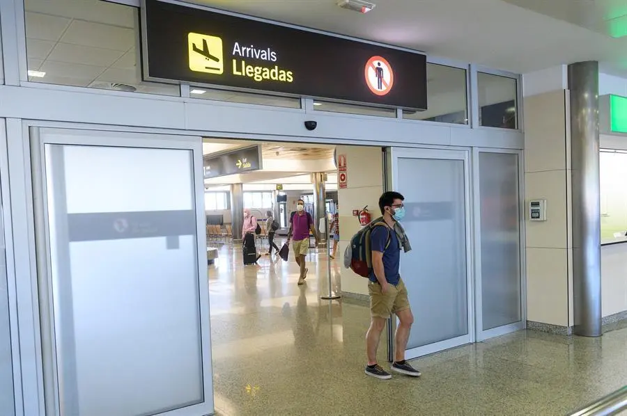 Viajeros en la zona de llegadas del aeropuerto Seve Ballesteros en Malia&ntilde;o (Cantabria), que han sido los primeros en aterrizar a bordo de un avi&oacute;n de la aerol&iacute;nea de bajo coste Ryanair, procedente de Valencia, tras tres meses sin actividad en el aeropuerto debido al coronavirus. EFE/Pedro Puente Hoyos