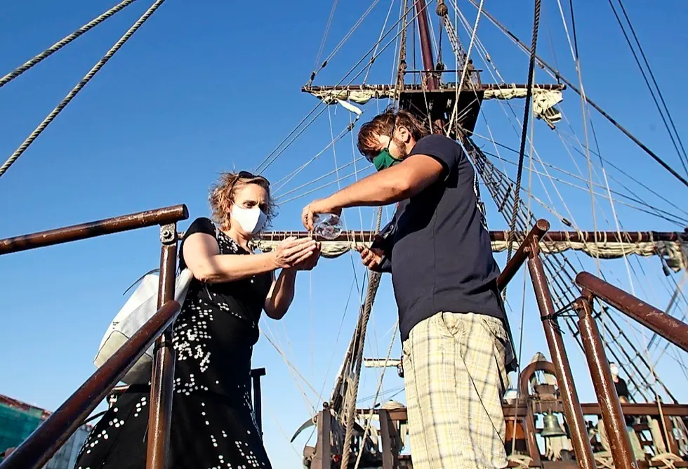 Un visitante se desinfecta en la entrada a la cubierta del 'Gale&oacute;n Andaluc&iacute;a'. / J. Ram&oacute;n Gonz&aacute;lez
