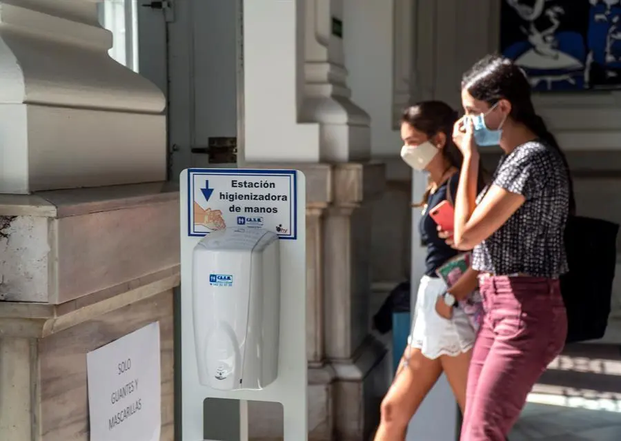 Dos personas camina con sus mascarillas por Santander. / Aguilera