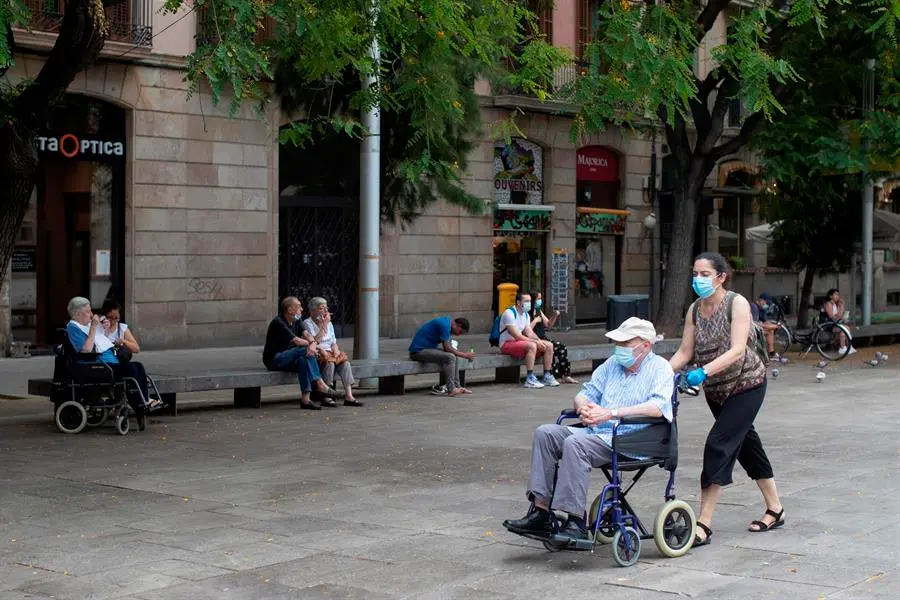 Una mujer empuja la silla de un se&ntilde;or mayor en el centro de Barcelona. EFE/ Marta P&eacute;rez/Archivo