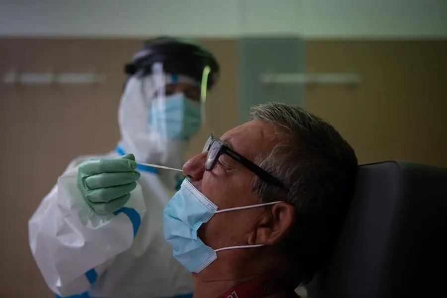 Una profesional sanitaria realiza una prueba PCR a un paciente en el CAP Raval Nord de Barcelona, este viernes. / EFE / Enric Fontcuberta