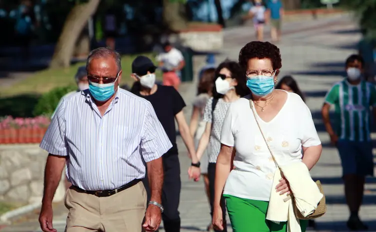 Dos personas caminan con su mascarilla en el paseo de la playa del Sardinero. / J. R.