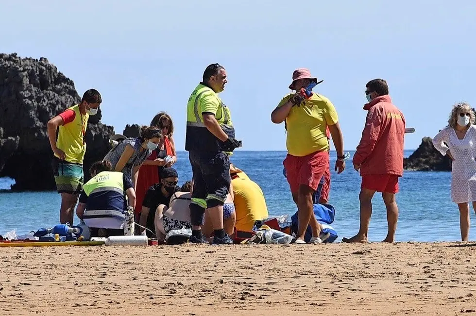 Realizando los ejercicios de reanimaci&oacute;n a la mujer de 85 a&ntilde;os en la playa de Ris en Noja. / ALERTA