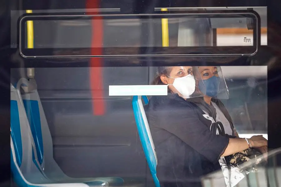 Dos mujeres con mascarilla y pantalla se sientan al lado en un autob&uacute;s de la EMT en Madrid. EFE/Emilio Naranjo/Archivo