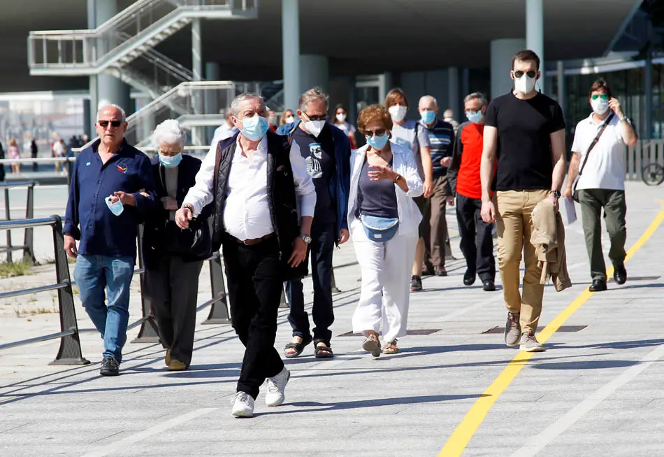 Varias persoans con mascarilla por las inmediaciones del Centro Bot&iacute;n en Santander. / J.R.