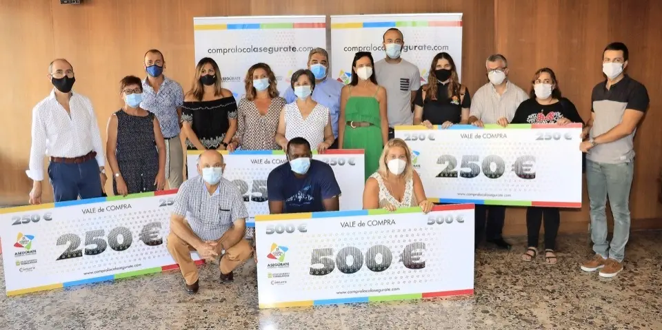 Galardonados y autoridades posan para la foto de familia tras la entrega de los vales de compra. / ALERTA