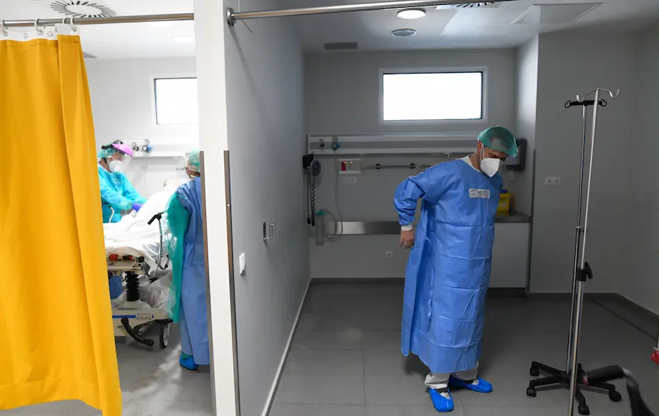 Un sanitario se coloca la protecci&oacute;n en la zona UCI del Hospital Marqu&eacute;s de Valdecilla. / Cubero