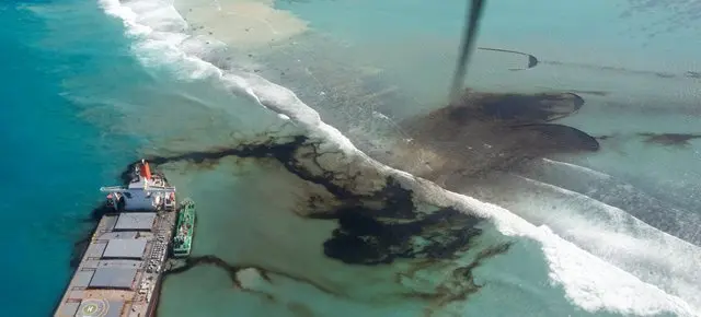 Una fotograf&iacute;a a&eacute;rea muestra el MV Wakashio, un buque granelero de bandera paname&ntilde;a de propiedad japonesa (arriba) con fugas de petr&oacute;leo cuando encall&oacute; en la costa sureste de Mauricio.
E. Press