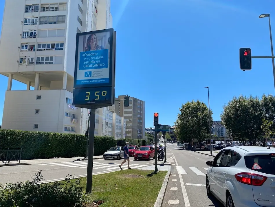 Un hombre pasea al lado de una se&ntilde;al que marca 35 grados en una jornada de altas temperaturas en la regi&oacute;n. / hardy