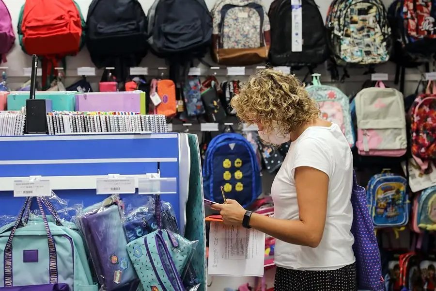 Una mujer, preparada con una lista de material escolar. / Ana Escobar
