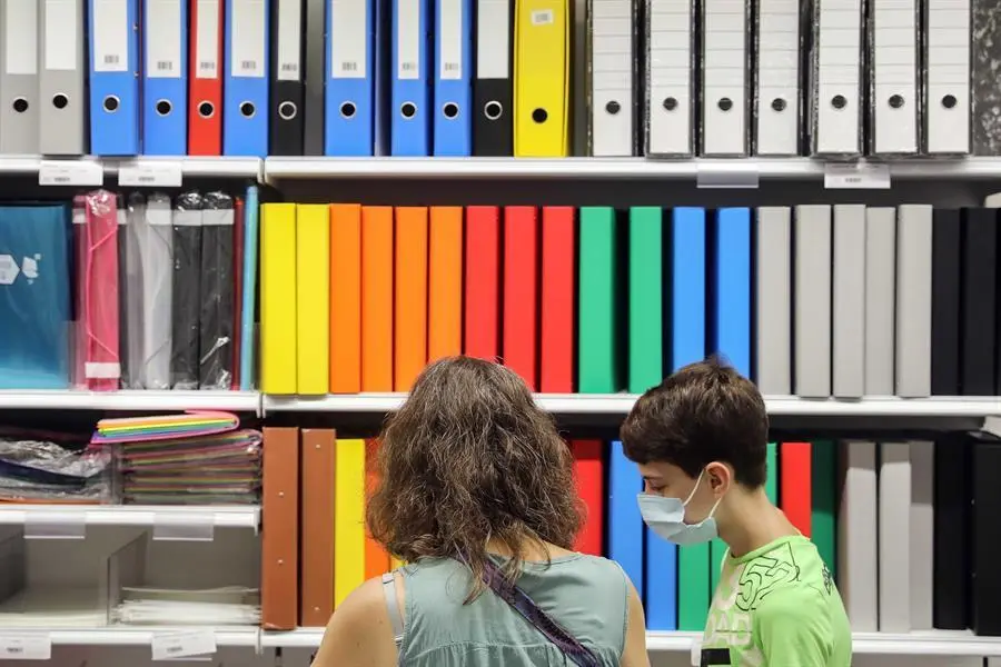 Una mujer y un ni&ntilde;o preparada consultan el precio de material escolar en una papeler&iacute;a de Val&eacute;ncia. La incertidumbre que genera la evoluci&oacute;n de la pandemia del coronavirus va a retrasar "hasta &uacute;ltima hora" el gasto habitual ante la vuelta al cole de las familias, que tendr&aacute;n que decidir si invertir en libros, material escolar y uniformes, o en ordenadores, tabletas o una buena conexi&oacute;n a internet. EFE/Ana Escobar