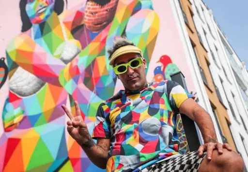 El artista callejero espa&ntilde;ol Okuda San Miguel muestra un signo de victoria frente a su obra de arte mural en Oldenburg, norte de Alemania, el 16 de septiembre de 2020. EFE/EPA/FOCKE STRANGMANN
